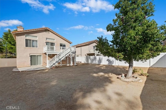 rear view of property featuring a wooden deck