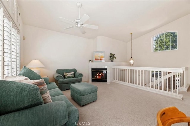 carpeted living room with ceiling fan, lofted ceiling, and a fireplace