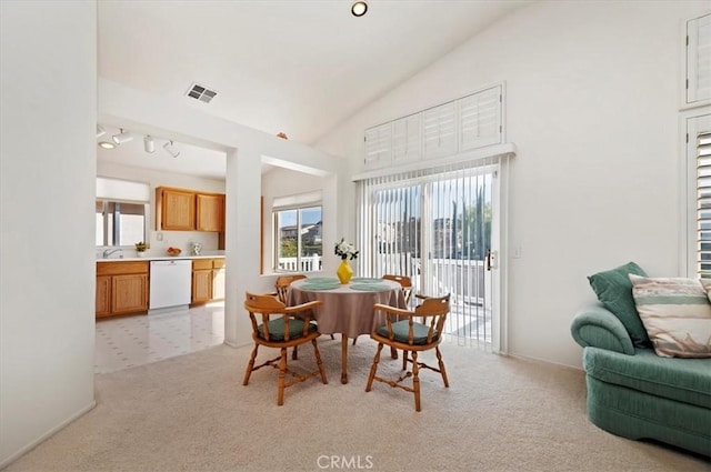 dining space featuring light carpet, a wealth of natural light, and lofted ceiling