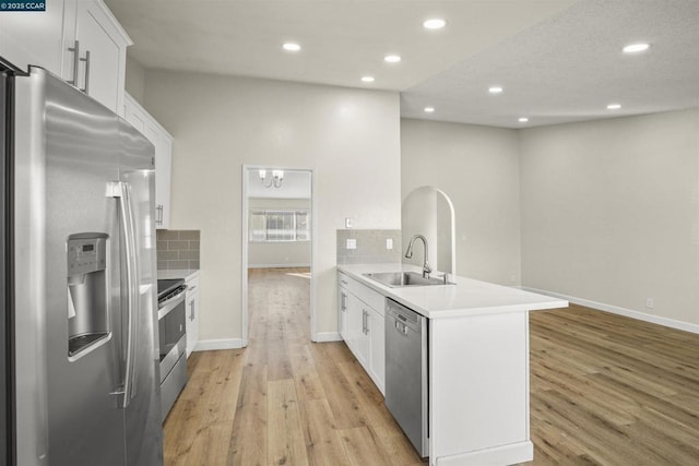 kitchen featuring white cabinetry, appliances with stainless steel finishes, kitchen peninsula, and tasteful backsplash