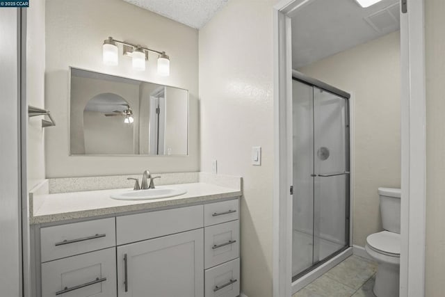 bathroom featuring toilet, a shower with door, tile patterned floors, and vanity