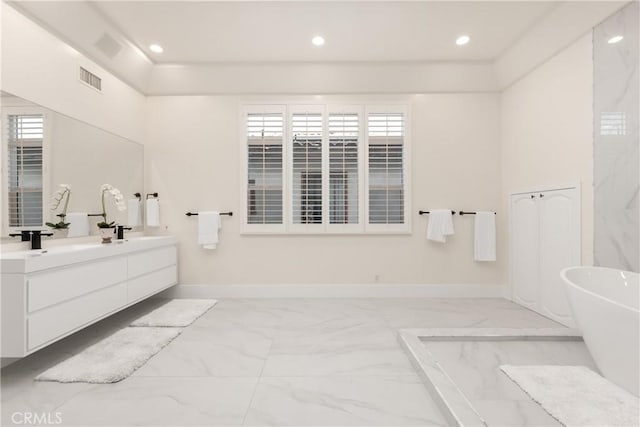 bathroom with a washtub and vanity