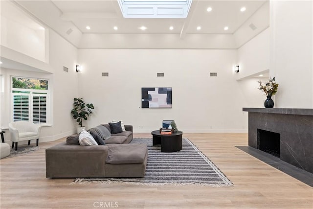 living room with light wood-type flooring and a towering ceiling