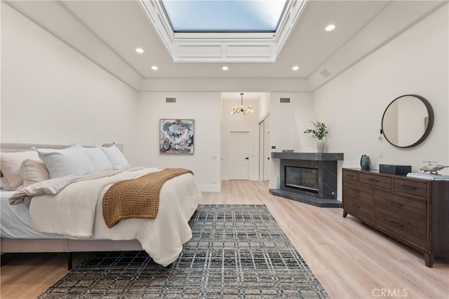 bedroom with light hardwood / wood-style flooring and a notable chandelier