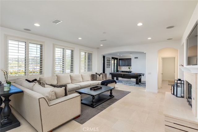 tiled living room featuring pool table and a fireplace