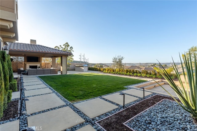 view of yard with a patio area and an outdoor living space with a fireplace