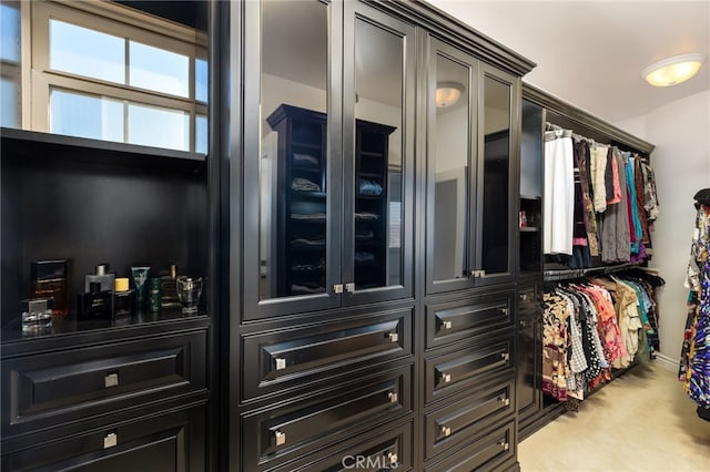 walk in closet featuring light carpet