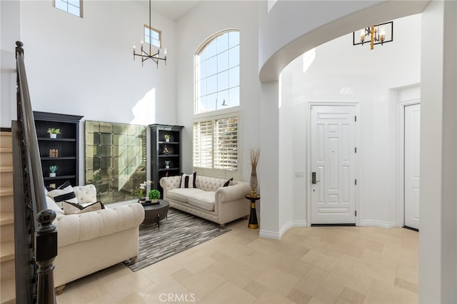 living room featuring a notable chandelier and a towering ceiling