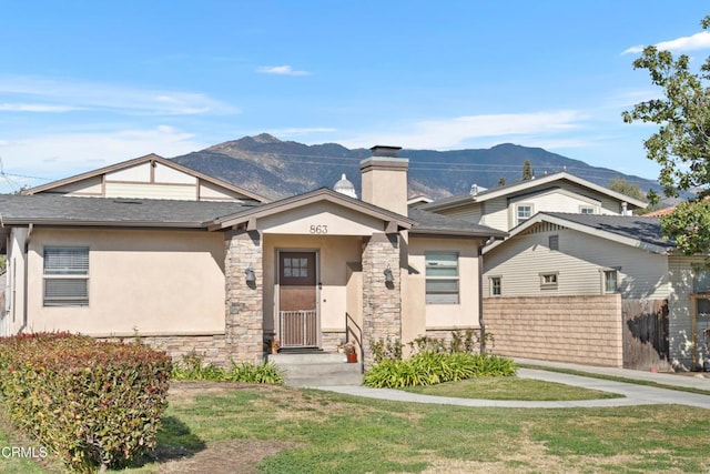 view of front facade with a mountain view and a front lawn