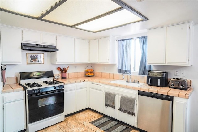 kitchen featuring stainless steel dishwasher, tile counters, white cabinetry, and white gas range