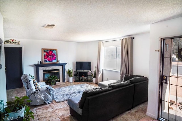 living room featuring a high end fireplace and a textured ceiling