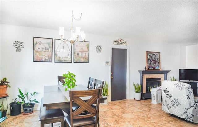 dining room featuring a chandelier, light tile patterned floors, and a textured ceiling