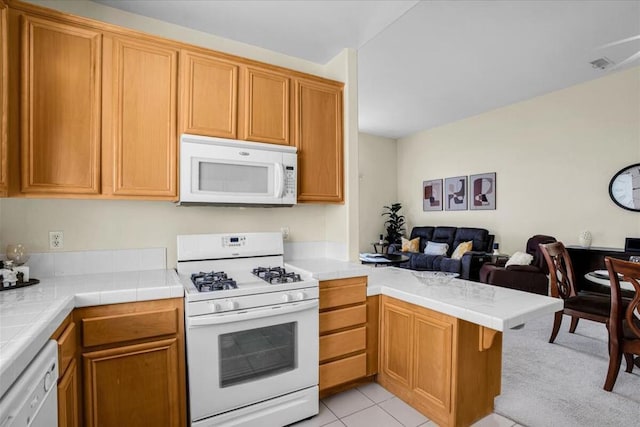 kitchen with kitchen peninsula, white appliances, tile countertops, and light tile patterned flooring