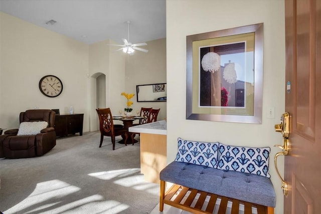 carpeted living room with ceiling fan