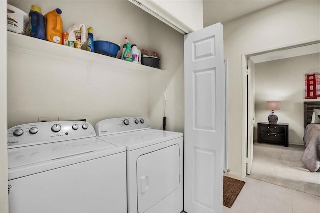 clothes washing area featuring independent washer and dryer and light colored carpet