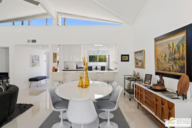 dining room featuring beamed ceiling, light tile patterned floors, high vaulted ceiling, and ceiling fan