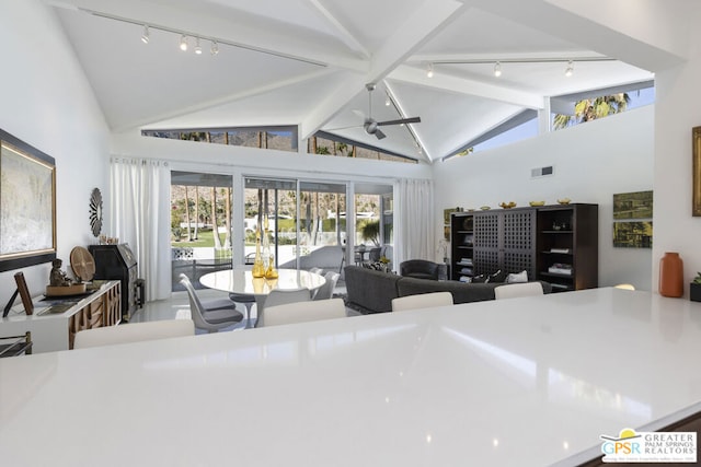 living room with vaulted ceiling with beams, ceiling fan, and a healthy amount of sunlight