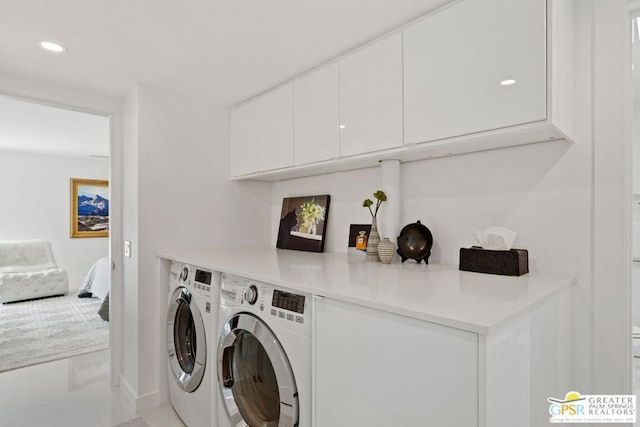 laundry area featuring separate washer and dryer and cabinets