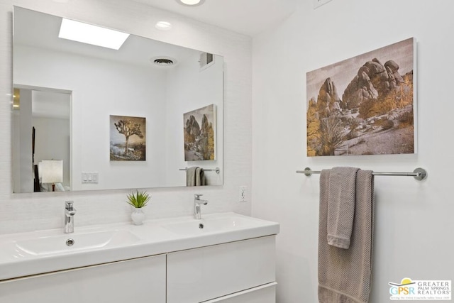 bathroom featuring vanity and a skylight