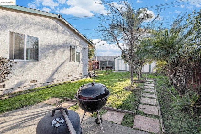 view of yard with an outdoor fire pit, a patio, and a storage unit