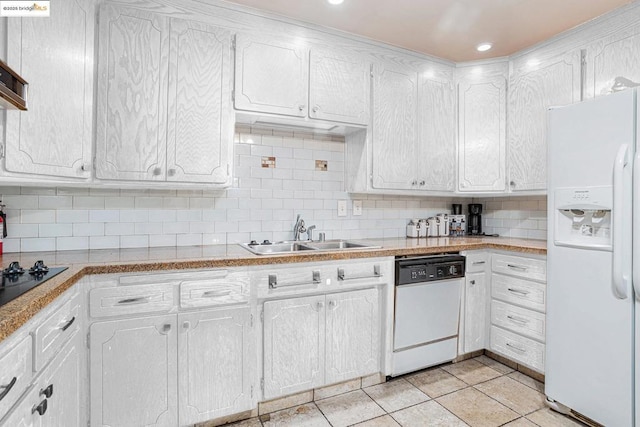 kitchen with decorative backsplash, white appliances, sink, light tile patterned floors, and white cabinetry