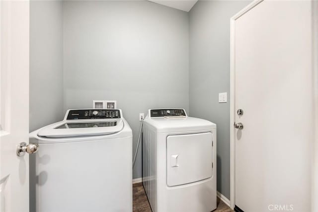 clothes washing area featuring washing machine and clothes dryer and dark hardwood / wood-style flooring