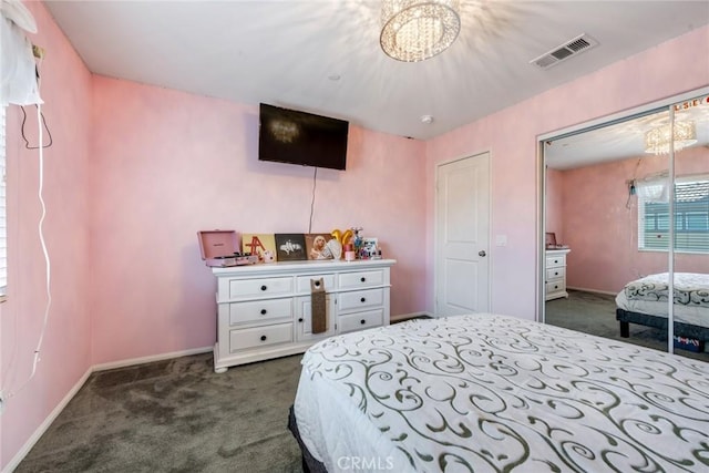 carpeted bedroom with a closet and a notable chandelier