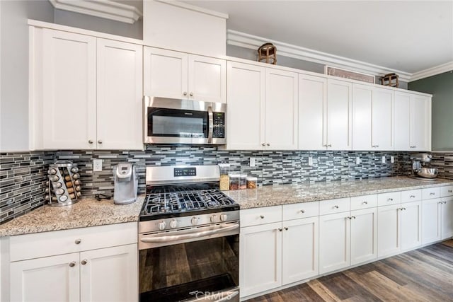 kitchen featuring light stone countertops, appliances with stainless steel finishes, tasteful backsplash, and white cabinetry