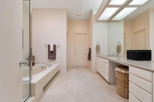 bathroom with vanity and tiled bath