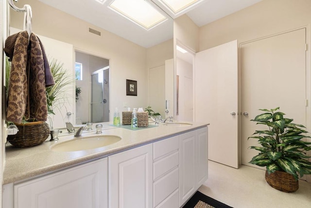 bathroom with vanity and a shower with door