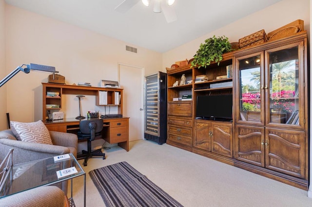 home office featuring light carpet and ceiling fan