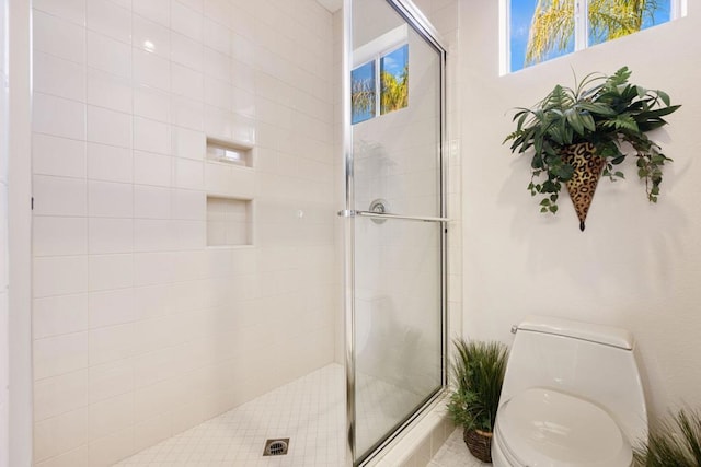 bathroom with an enclosed shower and toilet