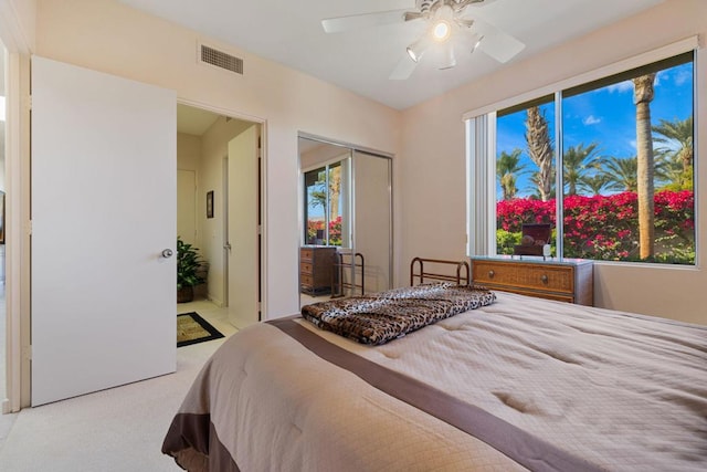 bedroom with a closet, light colored carpet, and ceiling fan