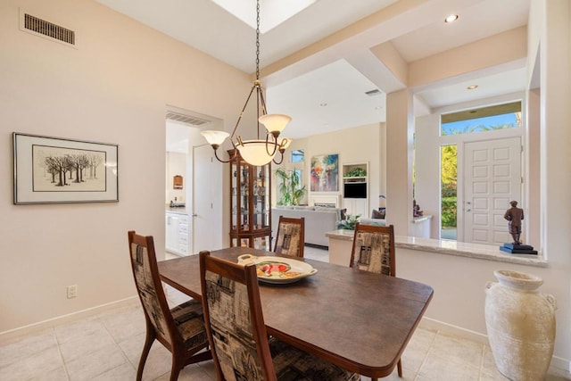 dining area with light tile patterned flooring and an inviting chandelier