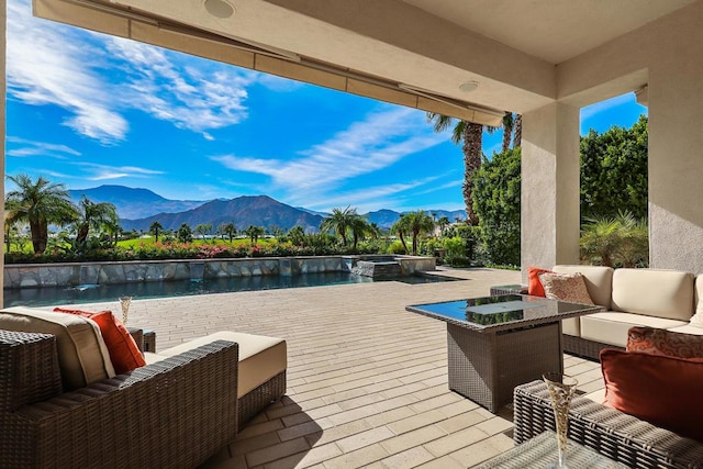 view of patio with outdoor lounge area, a water and mountain view, and a pool with hot tub