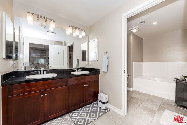 bathroom featuring tile patterned floors, a bathtub, and vanity