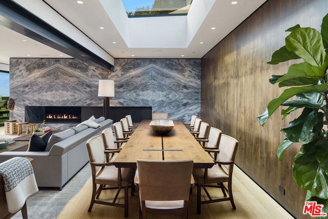 dining room featuring a skylight and an outdoor fireplace