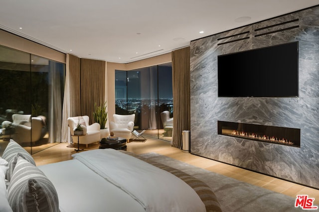 bedroom featuring light hardwood / wood-style floors, a fireplace, and a closet