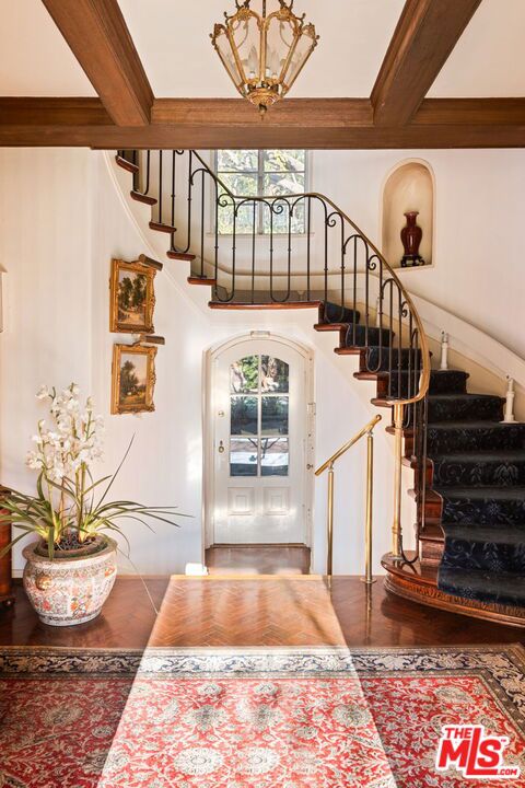 stairway with beam ceiling and hardwood / wood-style flooring