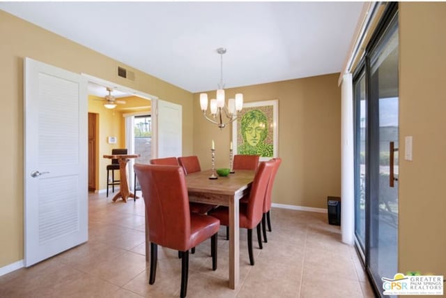 tiled dining space featuring ceiling fan with notable chandelier