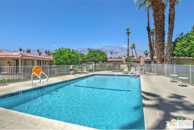 view of pool featuring a mountain view and a patio area