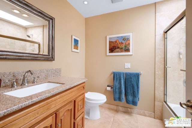 full bathroom featuring tile patterned flooring, vanity, toilet, and combined bath / shower with glass door