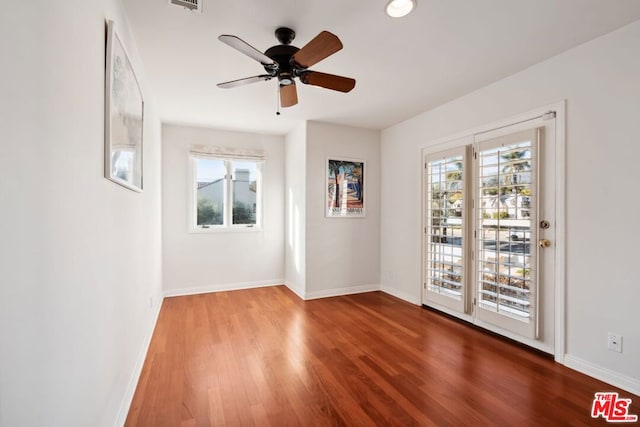 empty room featuring hardwood / wood-style flooring, plenty of natural light, and ceiling fan