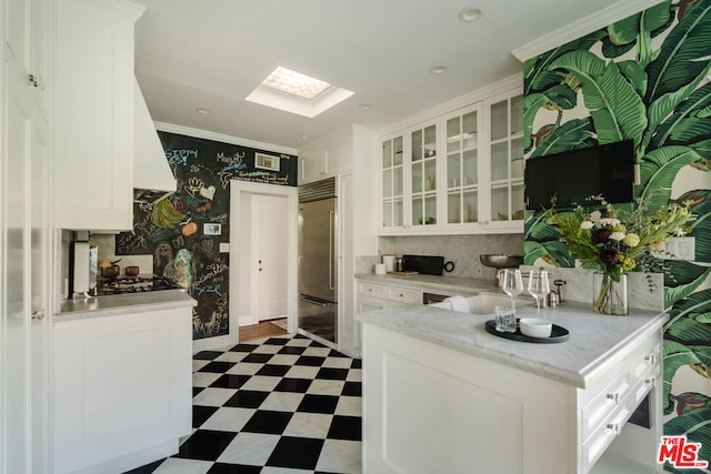 kitchen featuring white cabinetry and stainless steel built in fridge