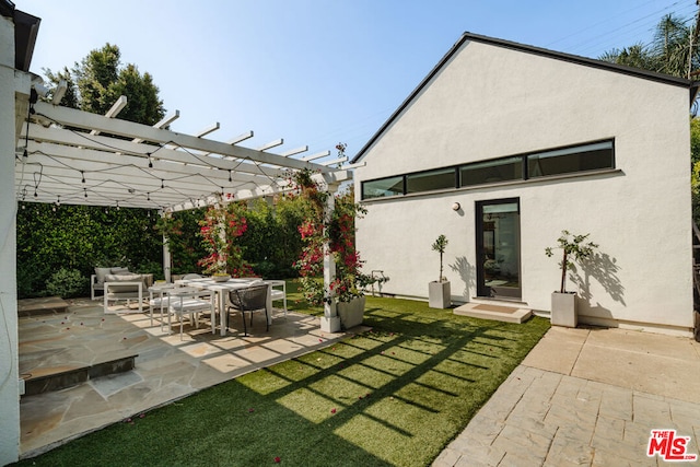 rear view of house featuring a yard, a pergola, and a patio area