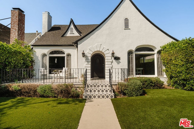 tudor home featuring a front lawn