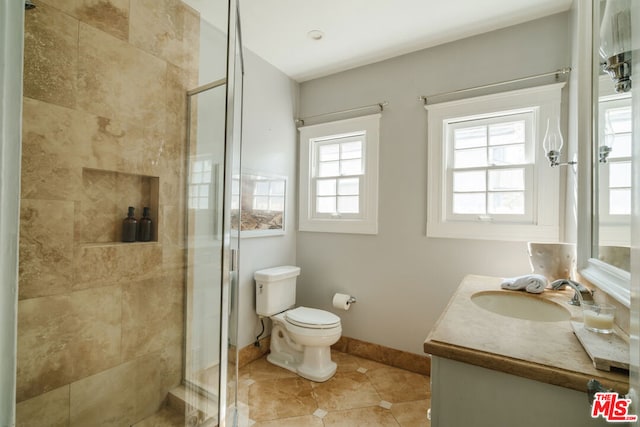 bathroom with tile patterned flooring, vanity, an enclosed shower, and toilet