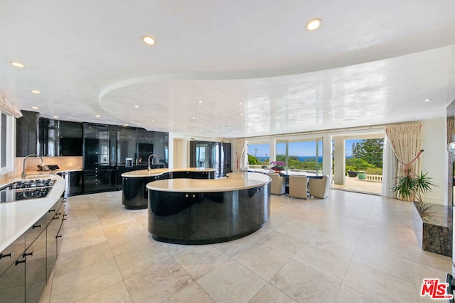 kitchen with a kitchen island with sink and light tile patterned flooring