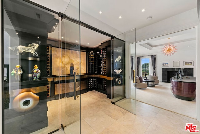 wine cellar featuring tile patterned floors, a fireplace, and a notable chandelier