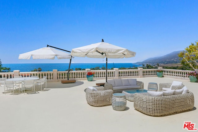 view of patio with an outdoor living space and a water view